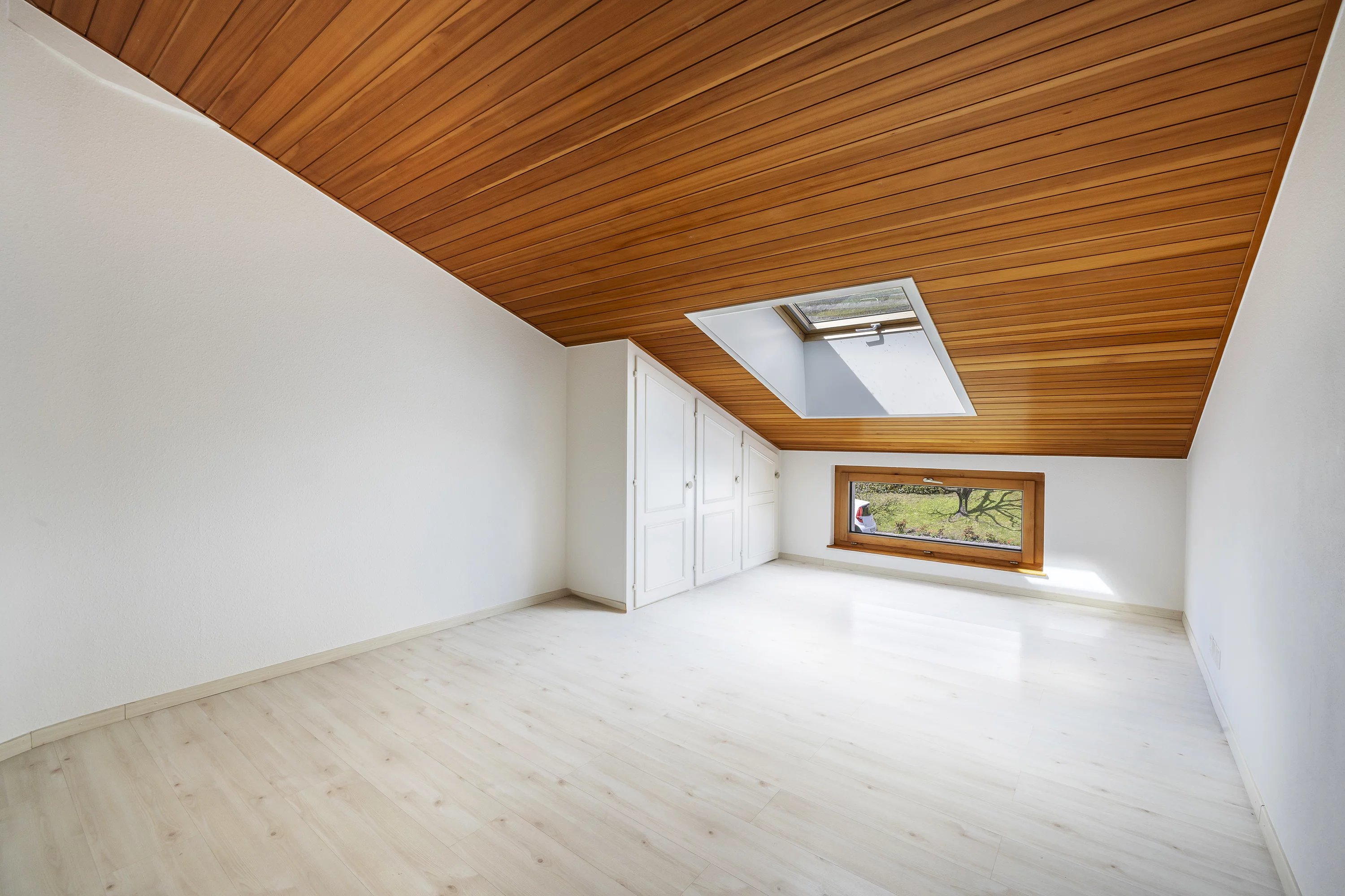 Heller Dachraum mit Holzdecke und Dachfenster