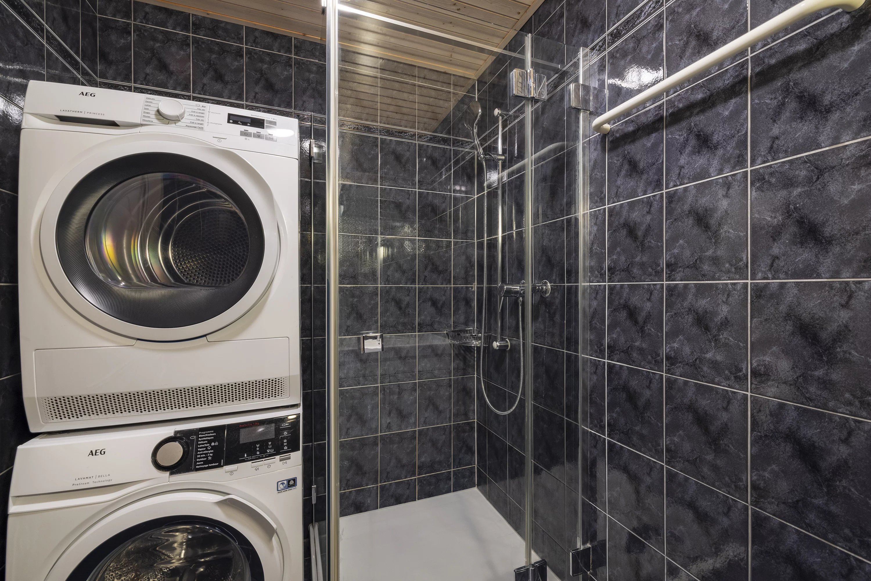 Badezimmer mit Waschtrockner und Dusche
