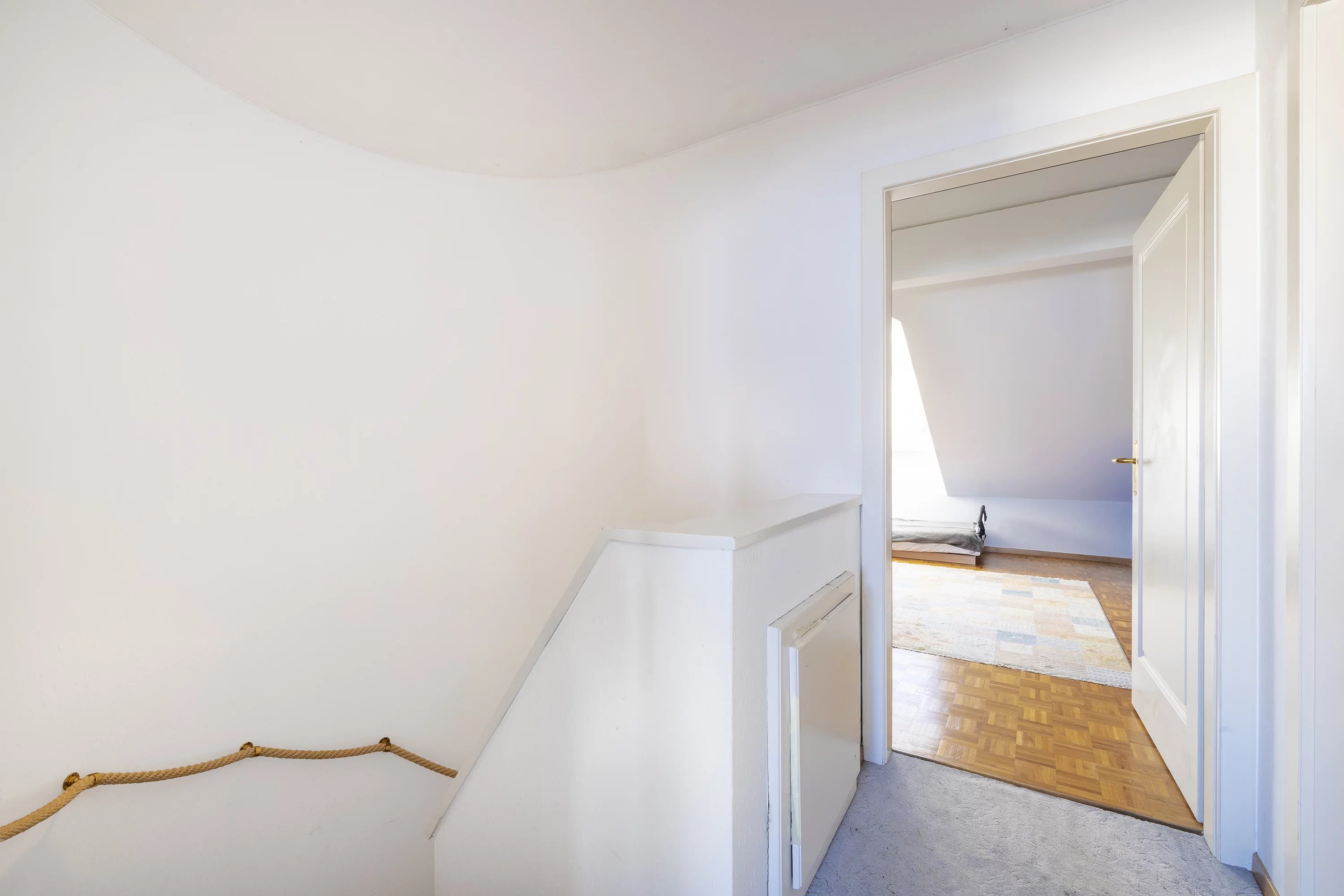 Treppenhaus mit Blick in ein helles Zimmer