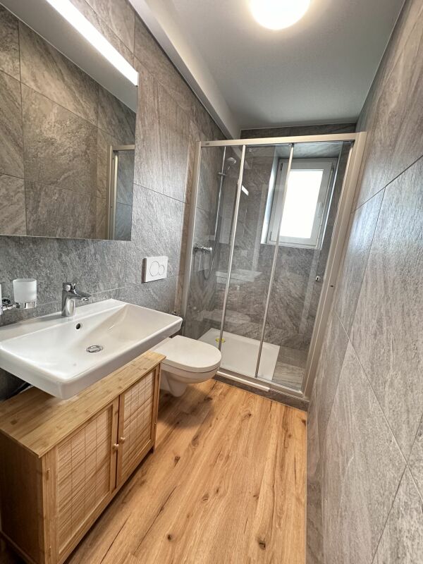 Modernes Badezimmer mit Holzwaschtisch und Glasdusche