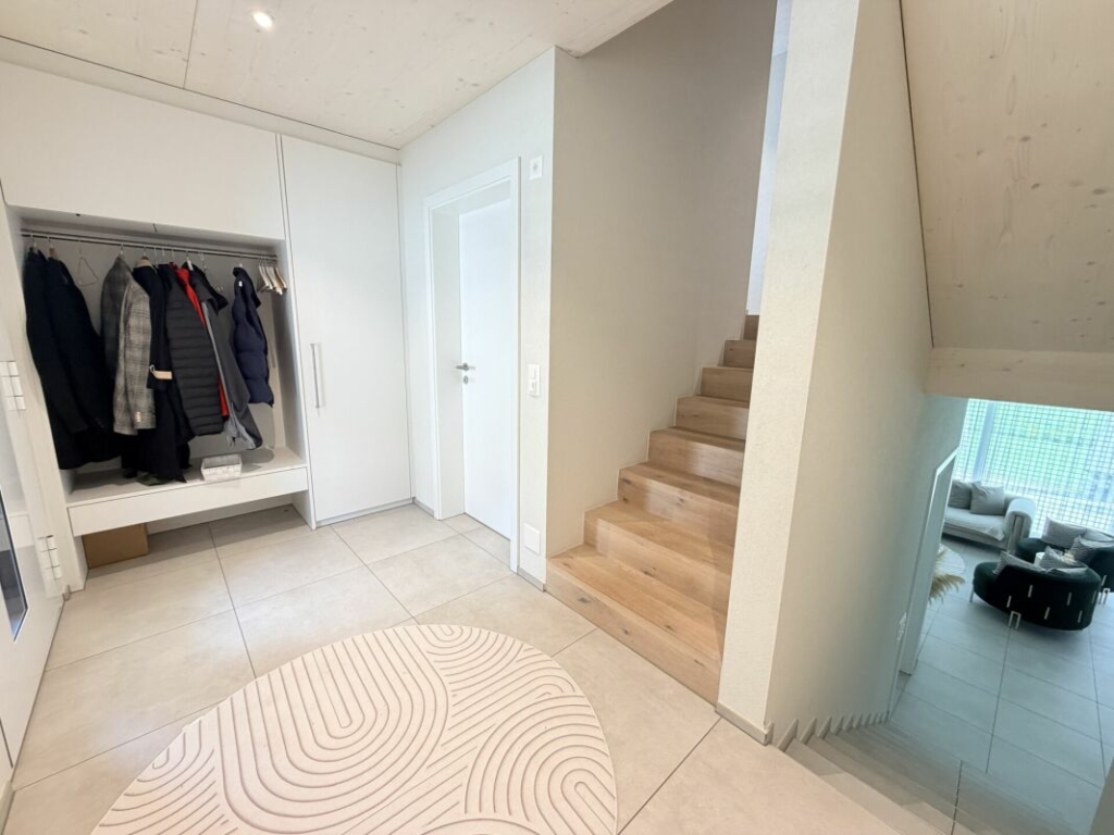 Heller Eingangsbereich mit Treppe und Garderobe