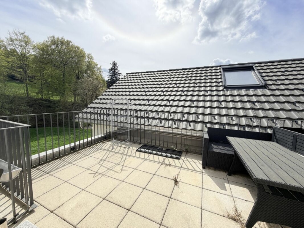 Dachterrasse mit Blick auf Walmdach und Grünanlage