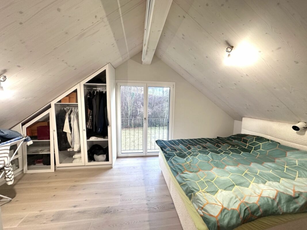 Dachgeschoss-Schlafzimmer mit Kleiderschrank und Balkontür