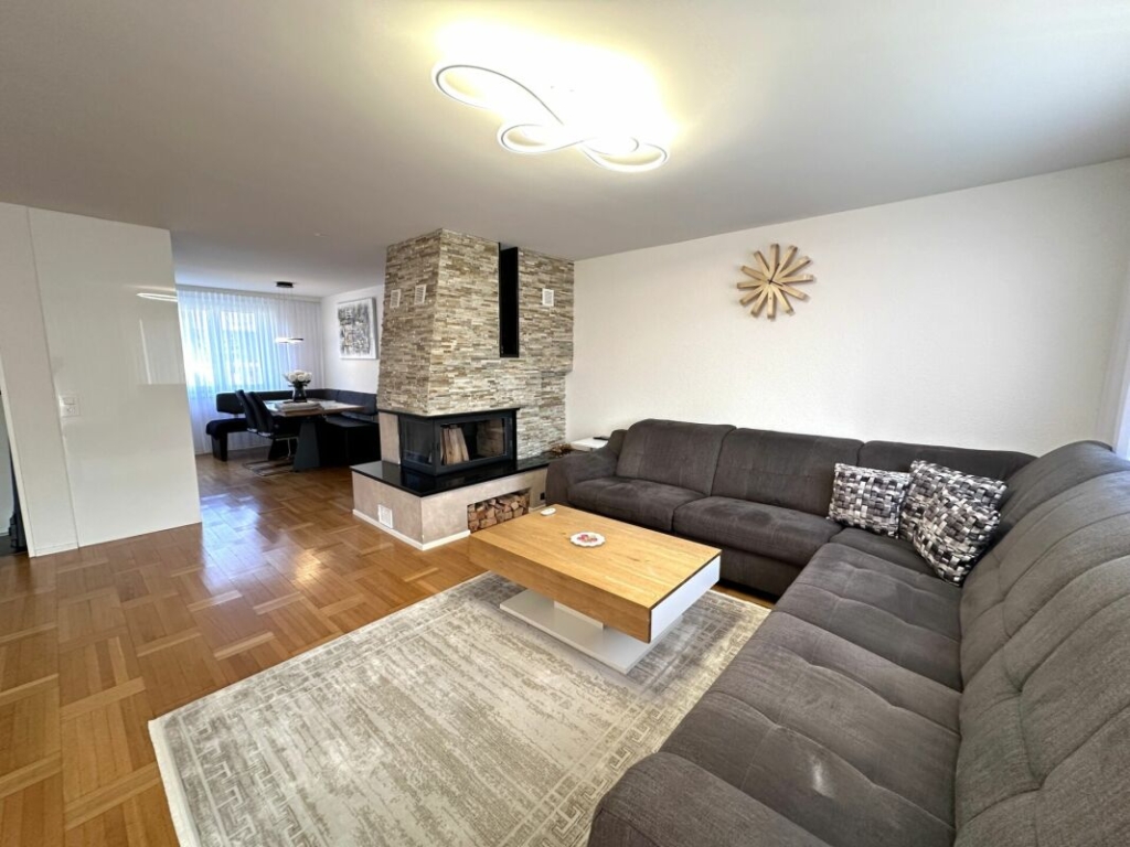 Wohnzimmer mit Kamin und offener Esszone