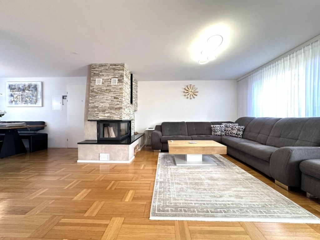Wohnzimmer mit Ecksofa und Kamin
