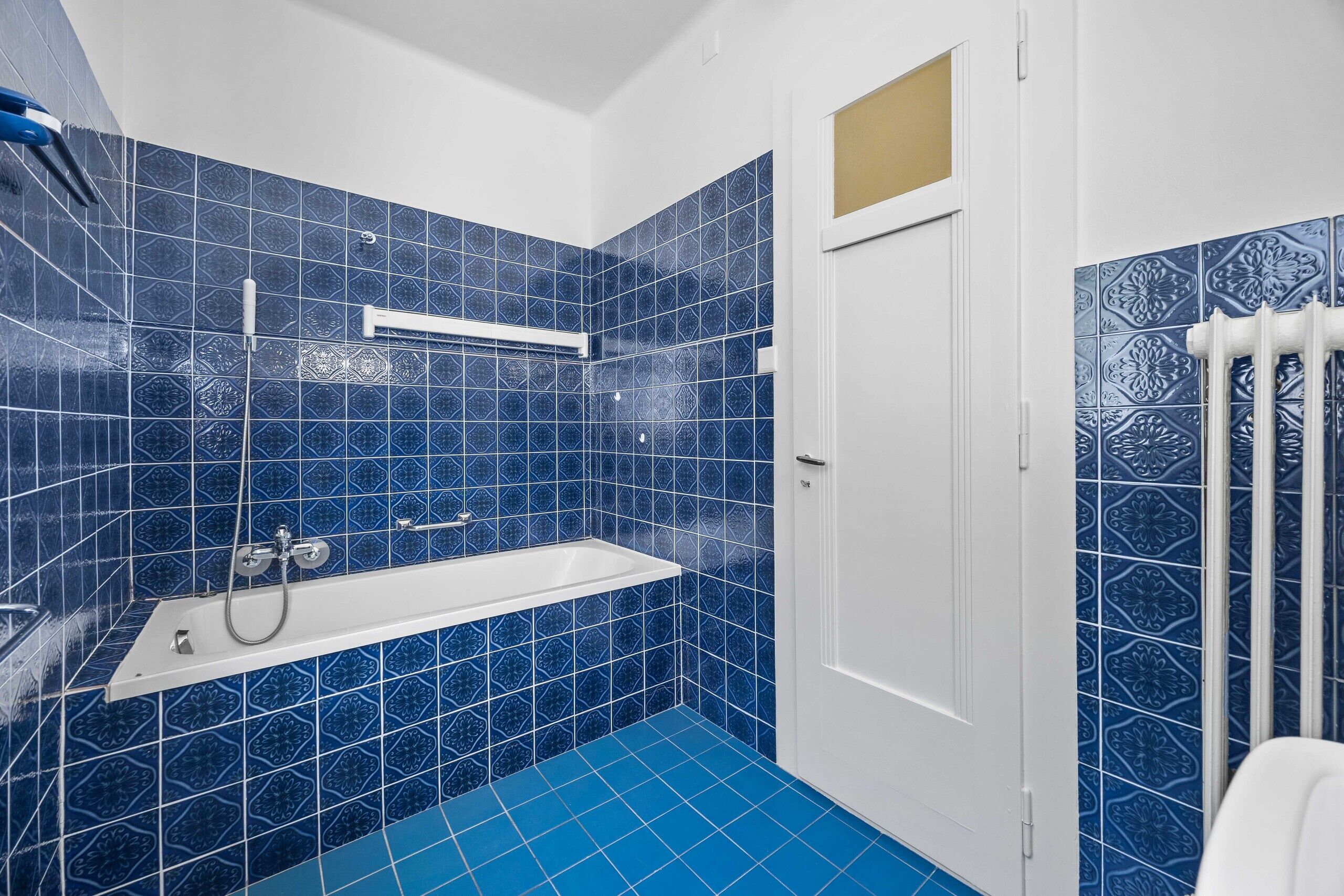 Blau gefliestes Badezimmer mit Wanne