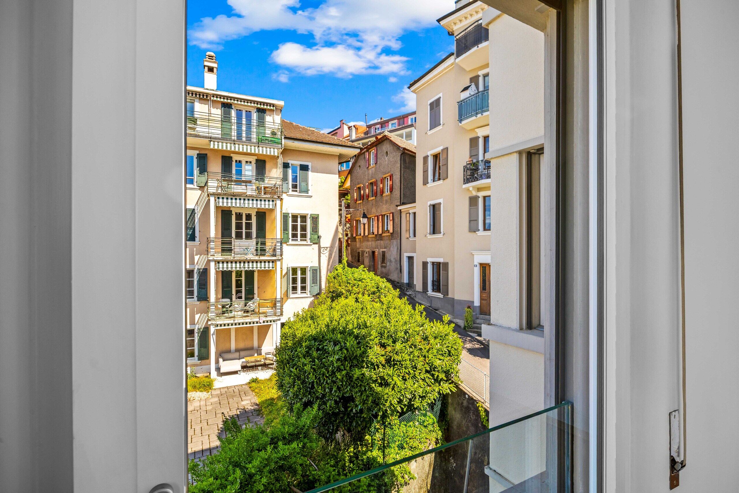 Blick aus dem Fenster auf Wohnhäuser und Innenhof