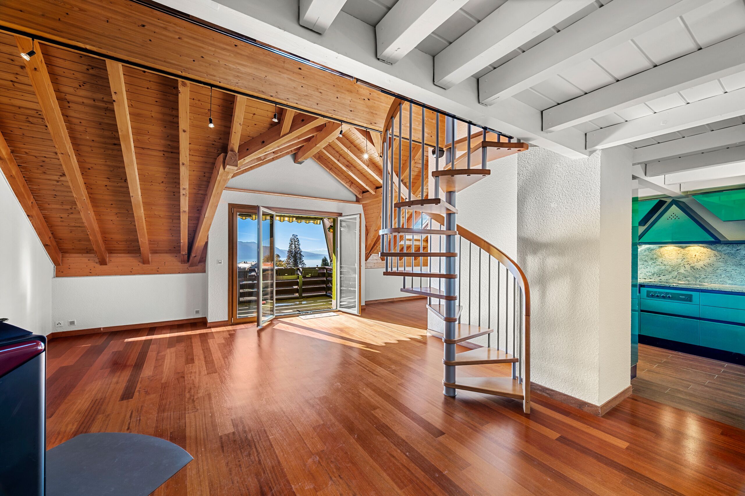 Offener Wohnbereich mit Holztreppe und Seeblick