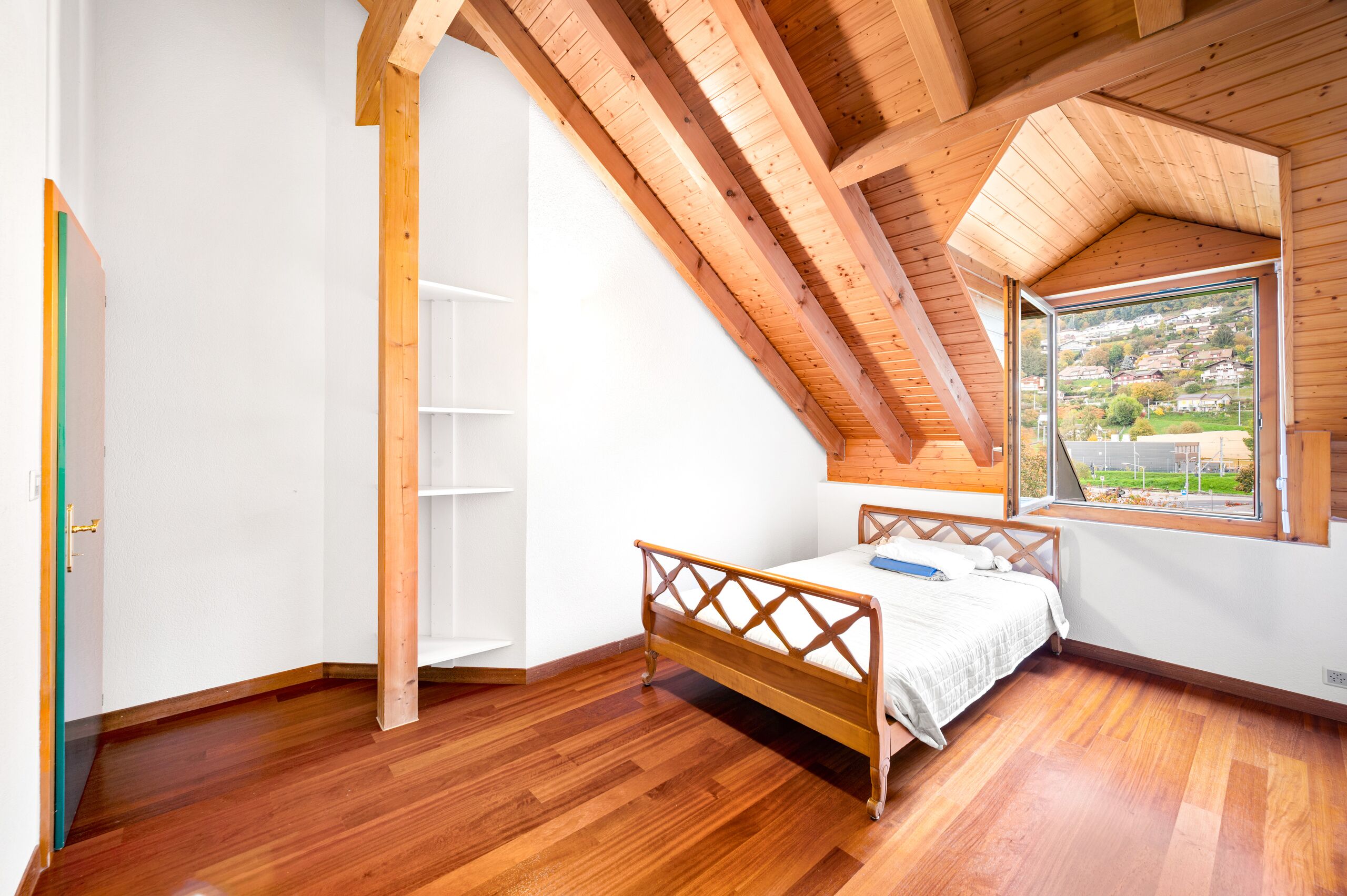 Helles Dachgeschoss-Schlafzimmer mit Holzbalkendecke
