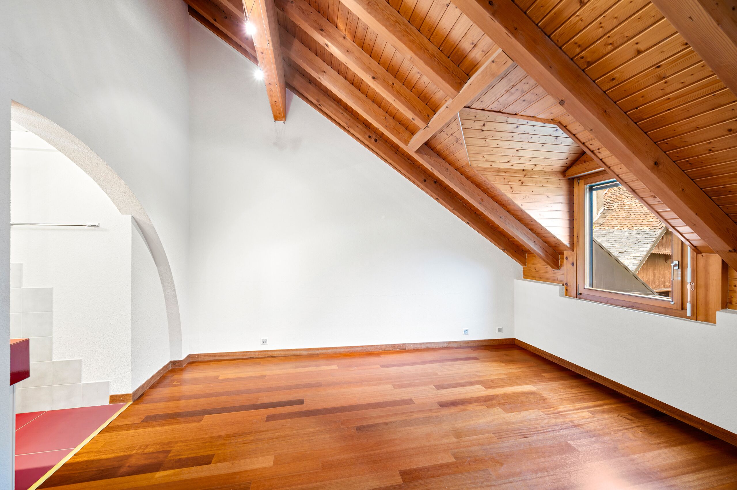 Dachgeschosszimmer mit Holzdecke und Parkettboden