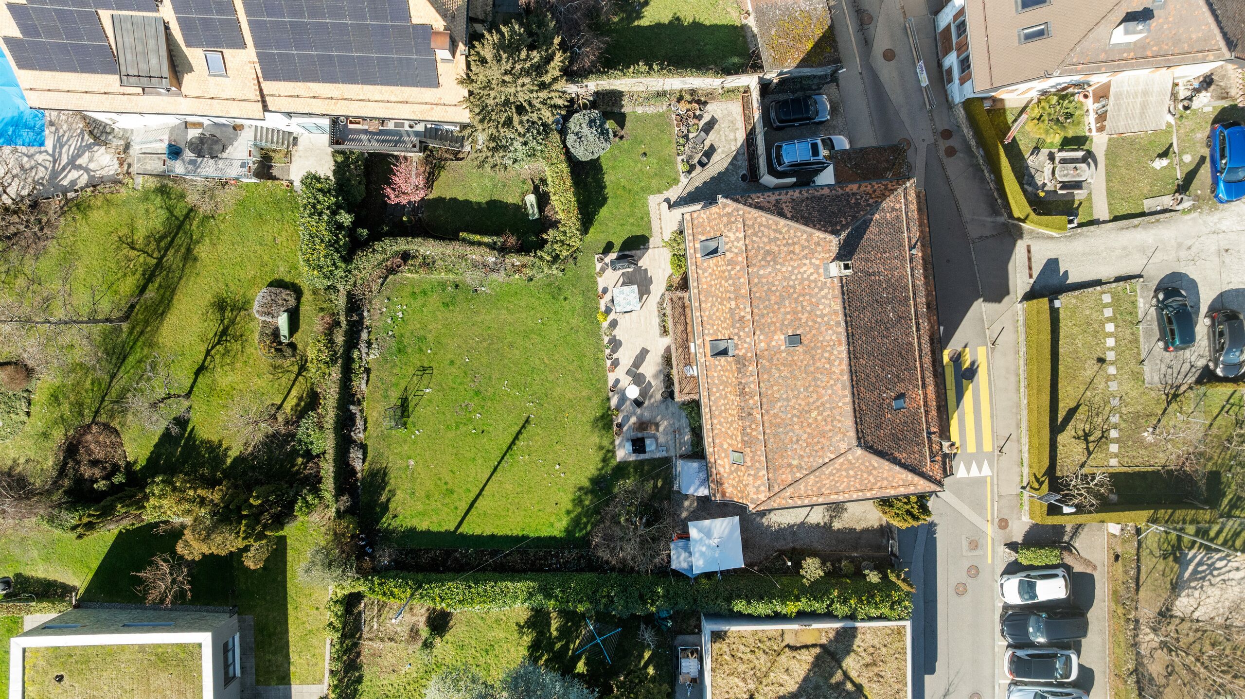 Luftaufnahme eines Wohnhauses mit Garten und Nachbargrundstücken