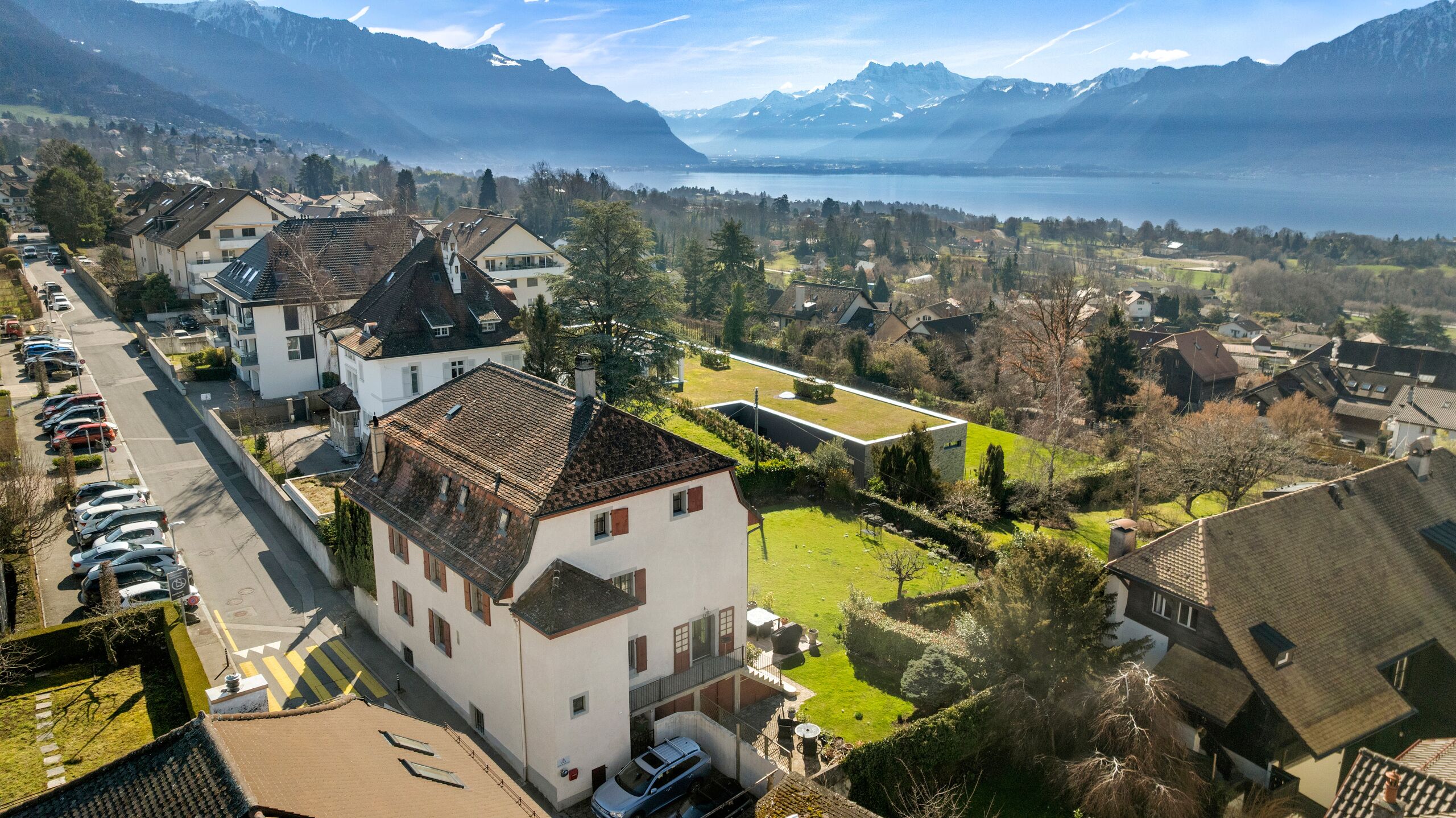Luftaufnahme eines Wohnviertels mit Berg- und Seeblick