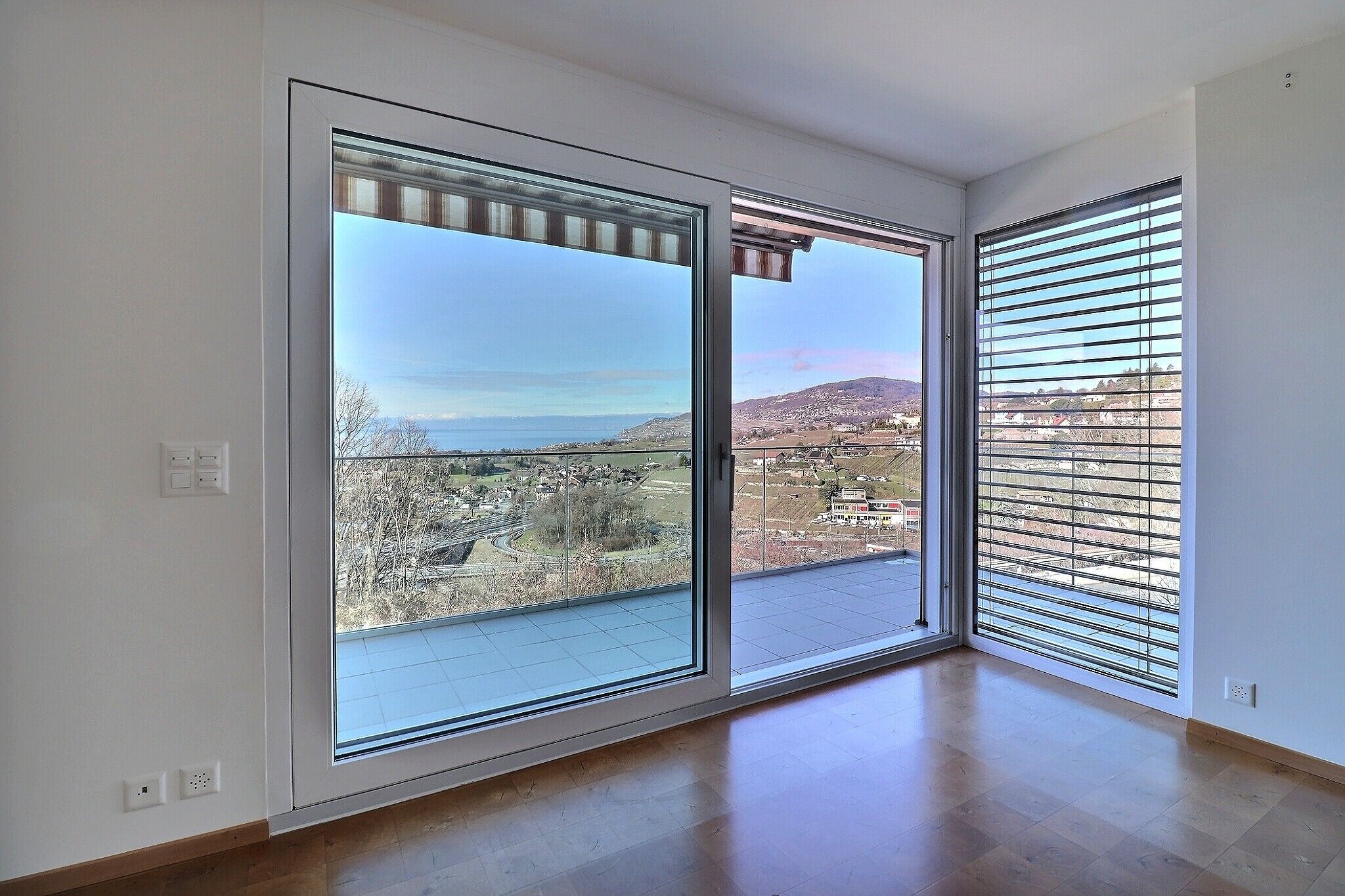 Heller Raum mit Panoramaausblick und Zugang zum Balkon