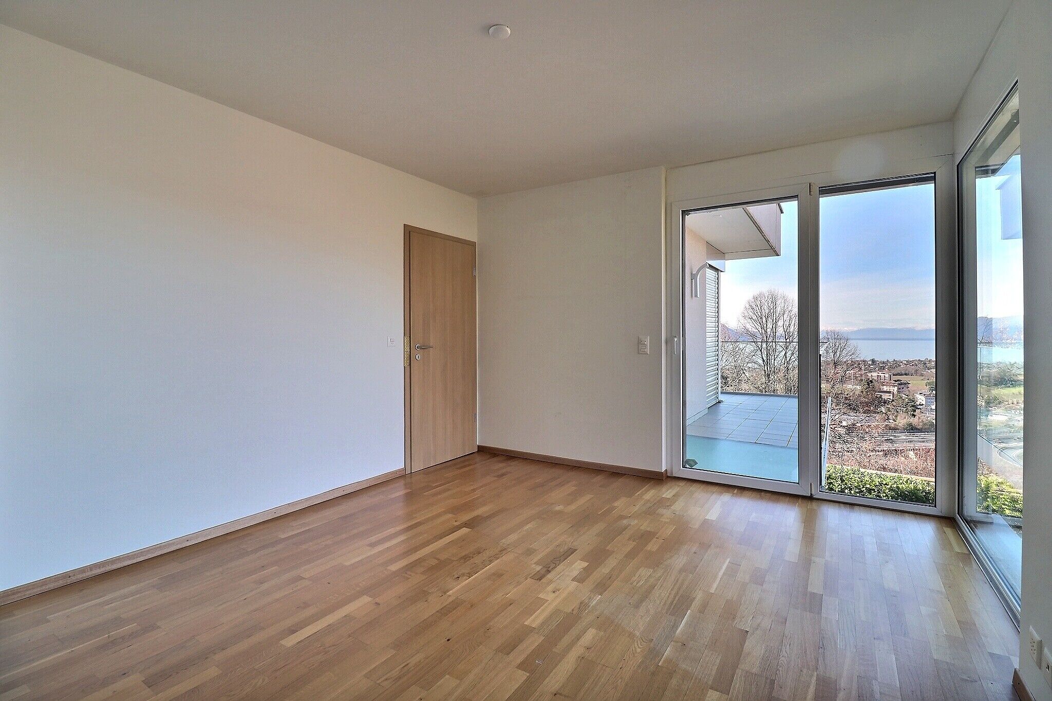 Leerer heller Raum mit Balkon- und Seeblick