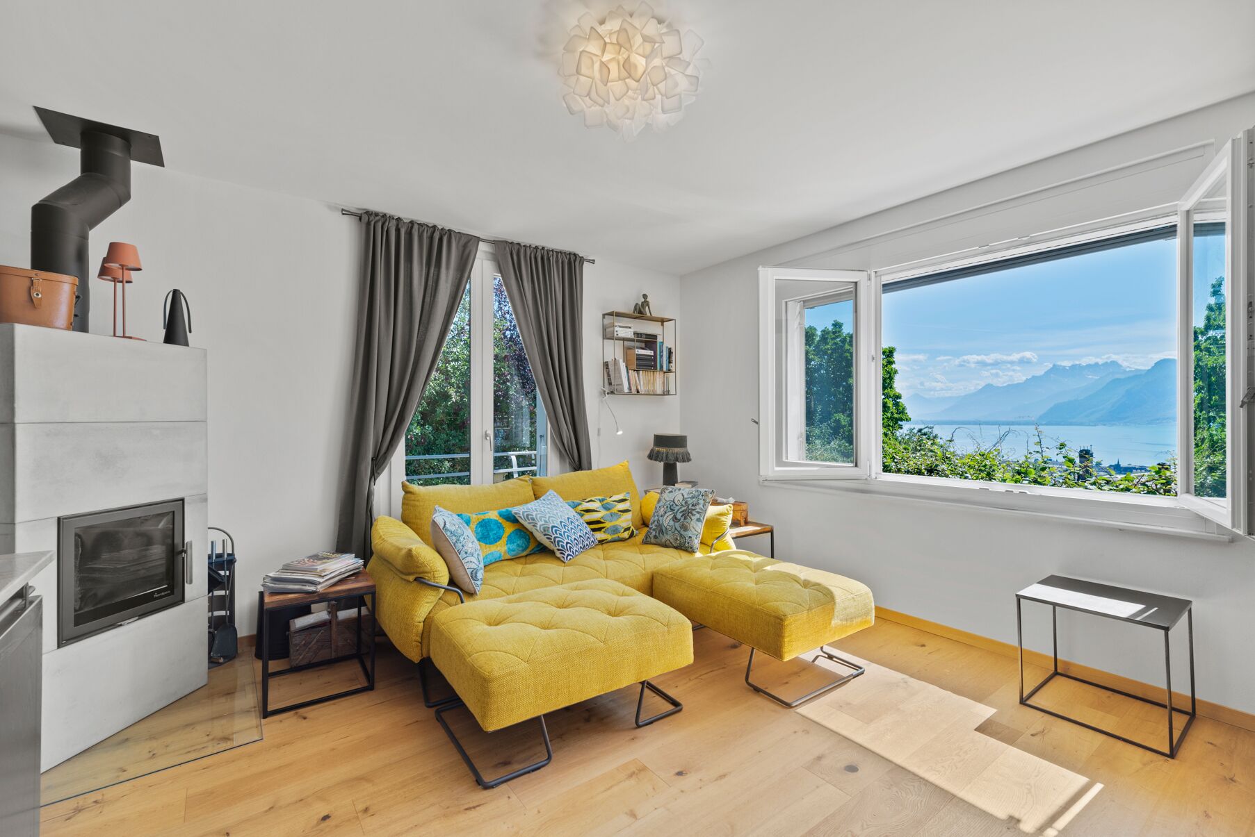 Helles Wohnzimmer mit Kamin und Seeblick