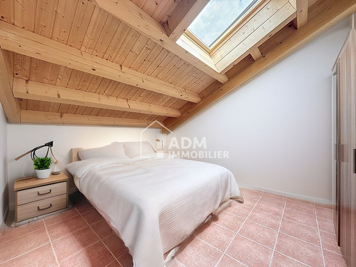 Dachgeschoss-Schlafzimmer mit Holzdecke und Dachfenster