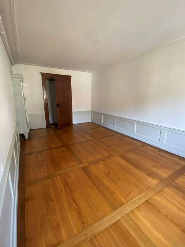 Leerer Altbau-Raum mit Holzdielen