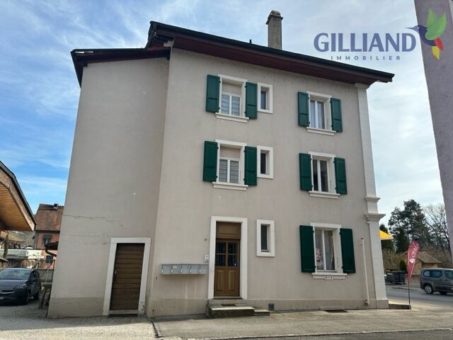 Mehrfamilienhaus mit grünen Fensterläden