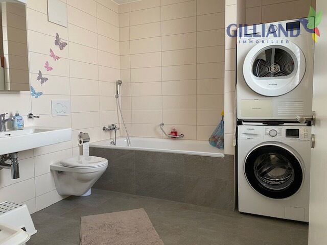 Badezimmer mit Badewanne und Waschtrockner
