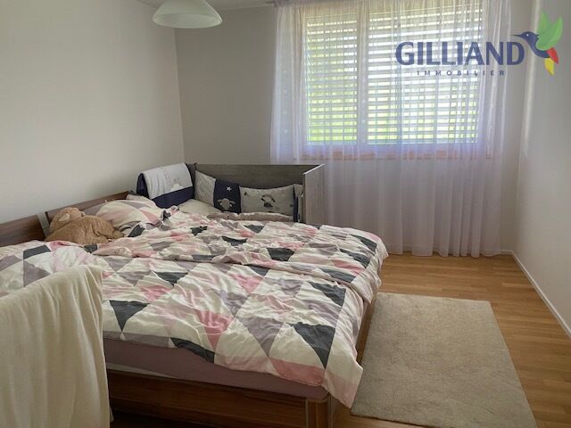 Helles Schlafzimmer mit Doppelbett und Fensterfront