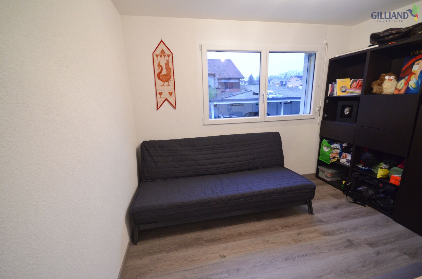 Kleines Zimmer mit Schlafsofa und Fenster