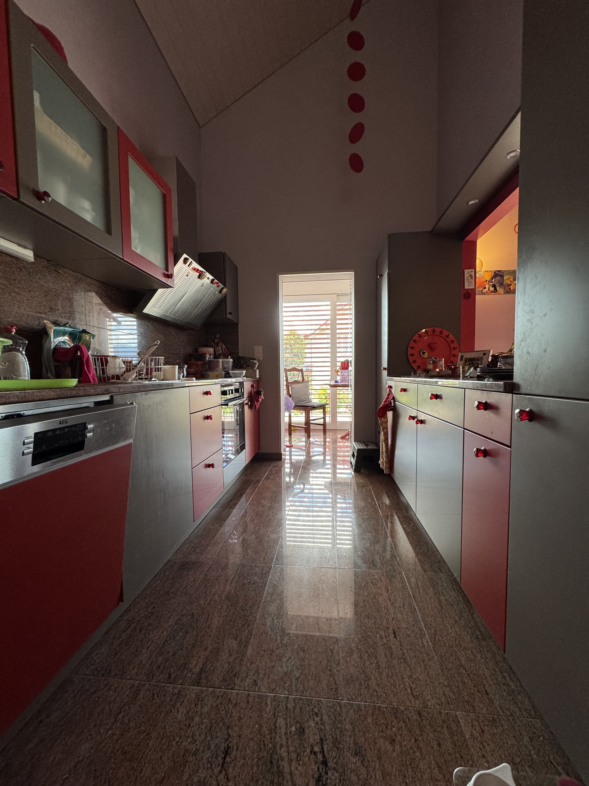 Schmale, moderne Küche mit Blick ins Licht