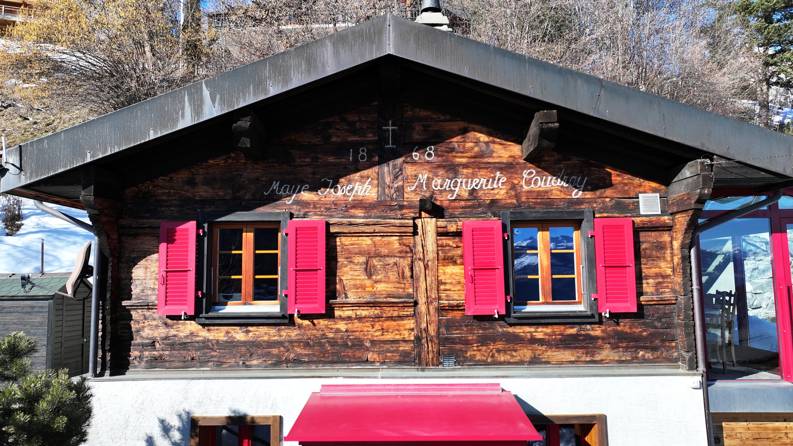 Berghütte mit Holzfassade und pinken Fensterläden