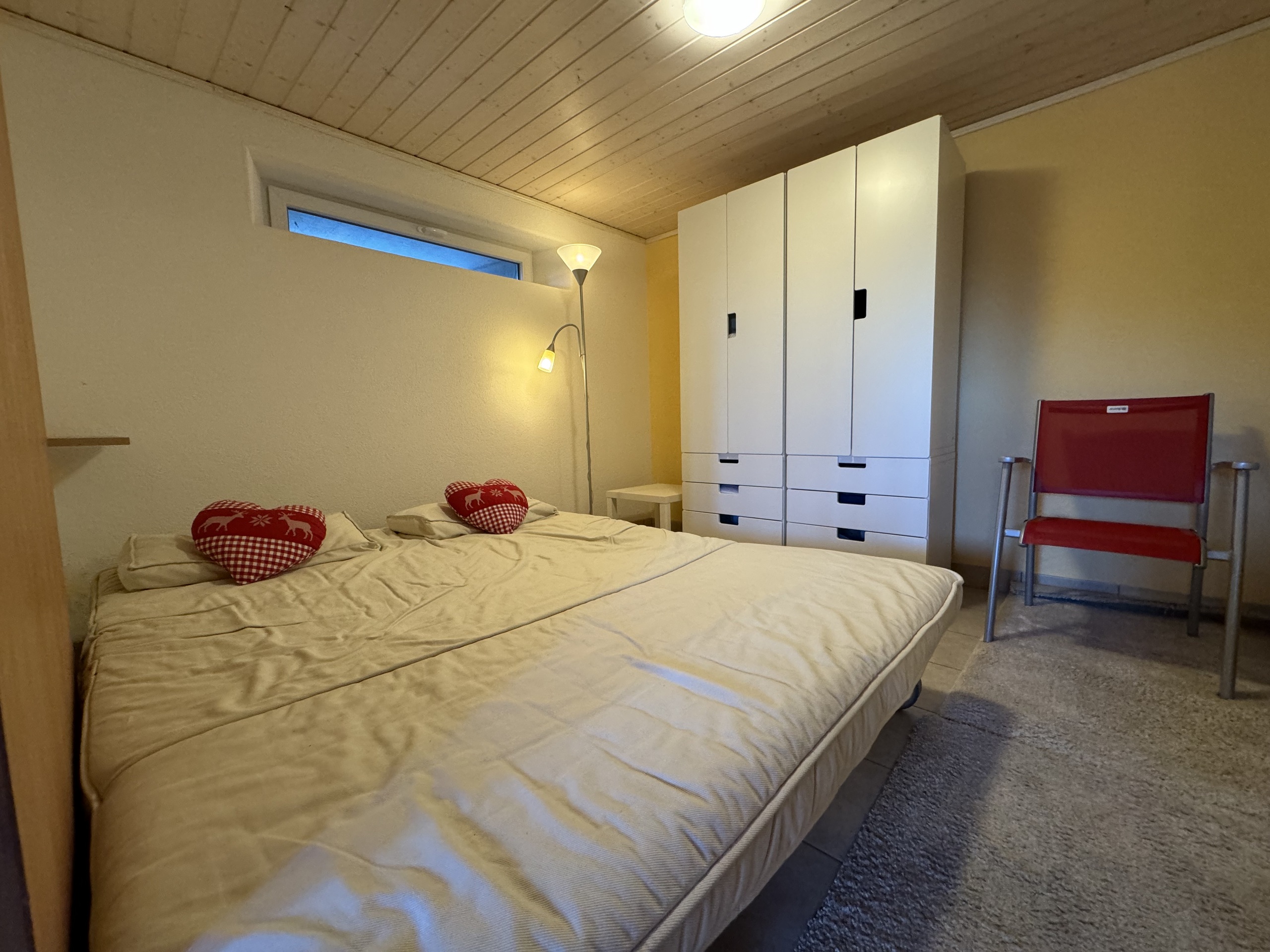Gemütliches Schlafzimmer mit Doppelbett und Kleiderschrank