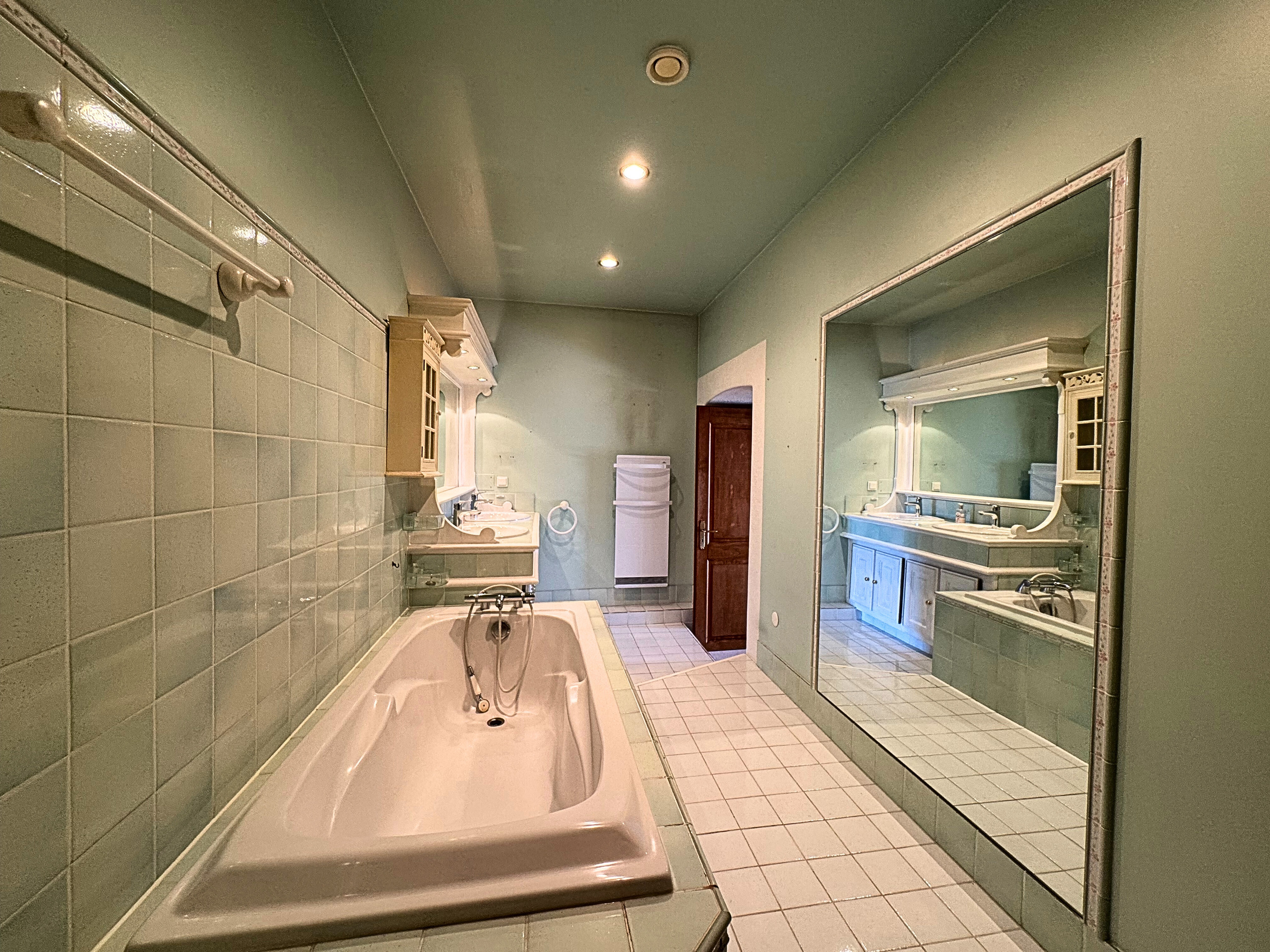 Großes Badezimmer mit Wanne und Spiegeln