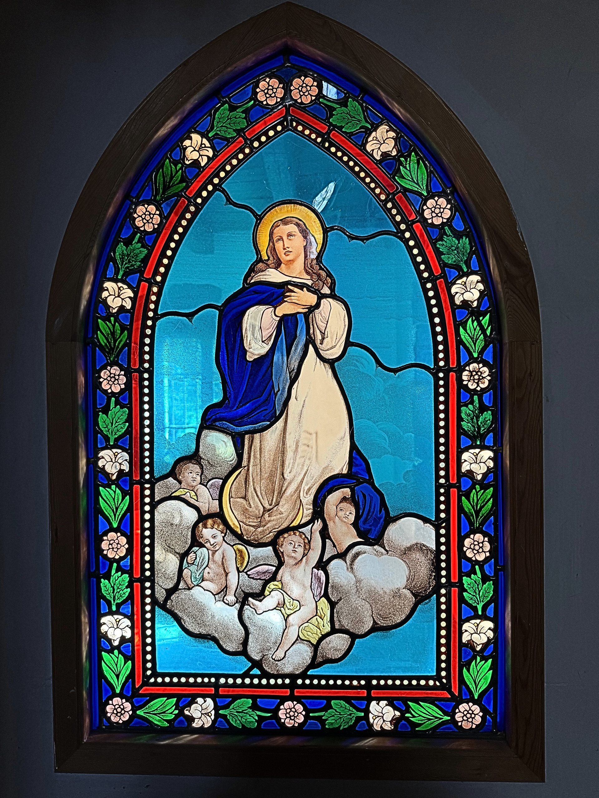 Buntes Kirchenfenster mit Heiligenfigur