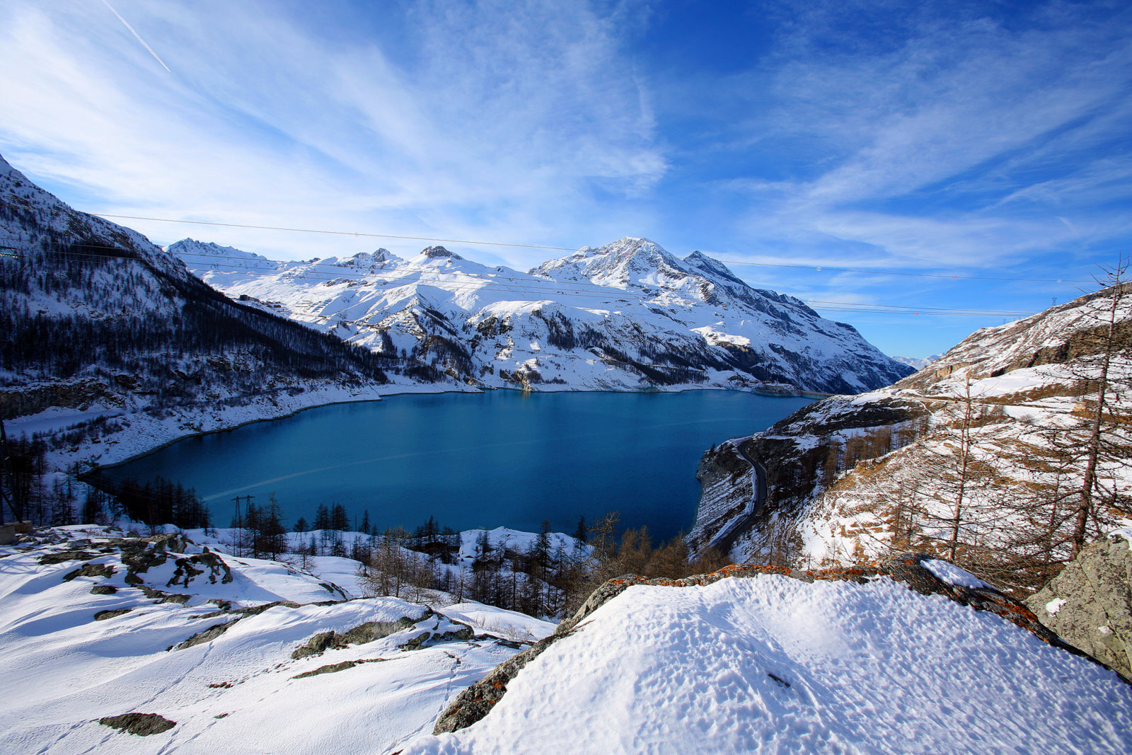 Bergsee mit verschneiten Alpen