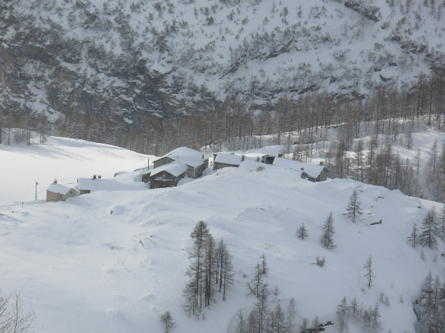 Verschneite Bergsiedlung in alpiner Landschaft