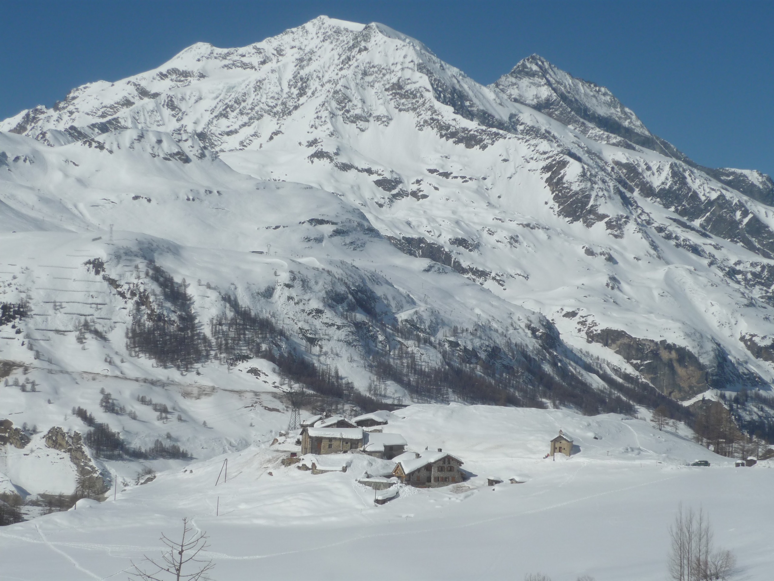 Schneebedeckte Berglandschaft mit vereinzelten Gebäuden