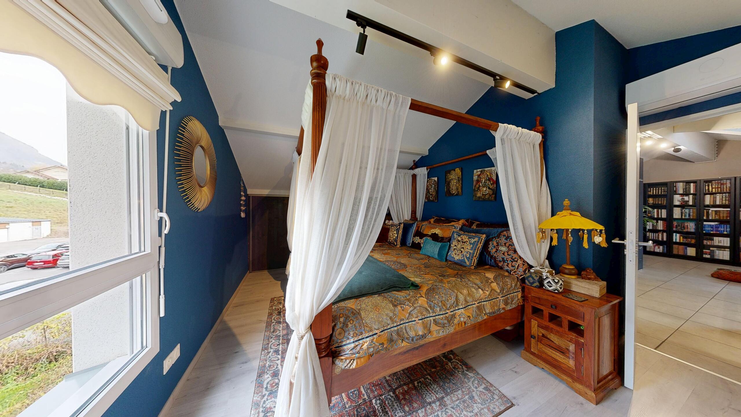 Exotisches Schlafzimmer mit Himmelbett und tiefblauen Wänden
