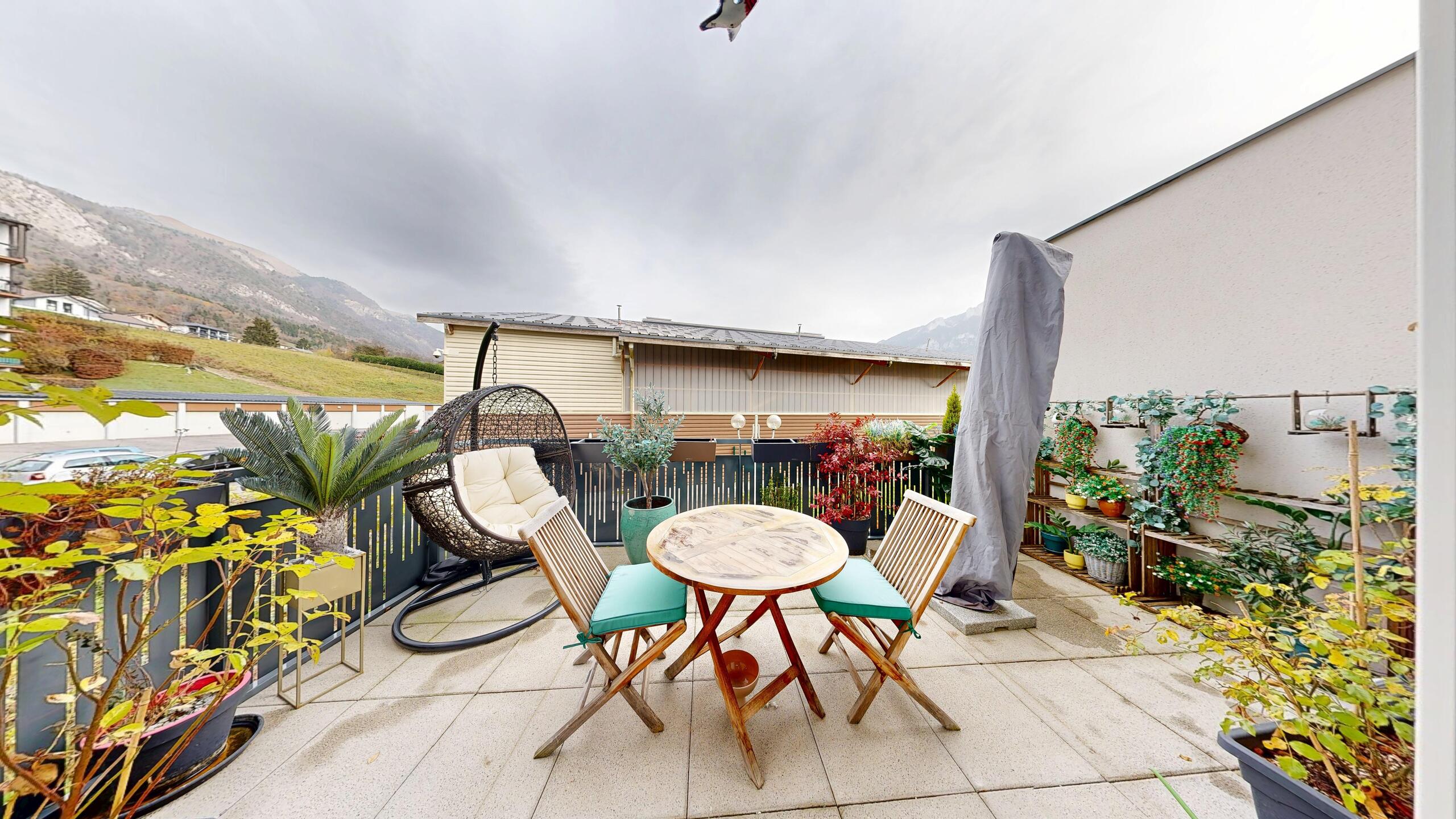 Balkon mit Gartenmöbeln und Bergblick