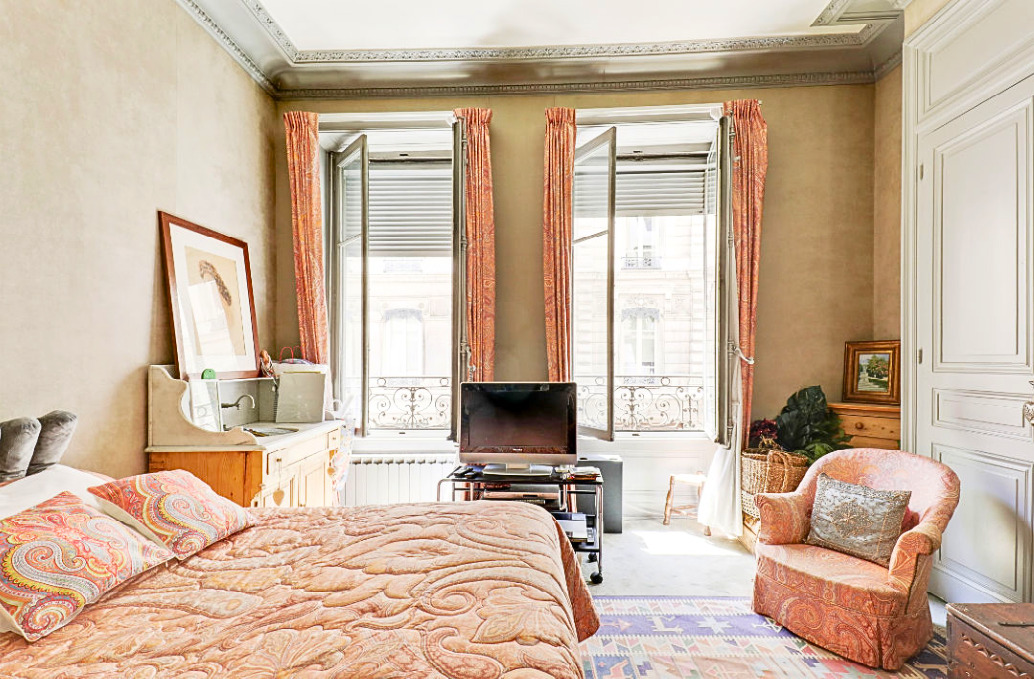 Helles Schlafzimmer mit hohen Fenstern und klassischer Einrichtung