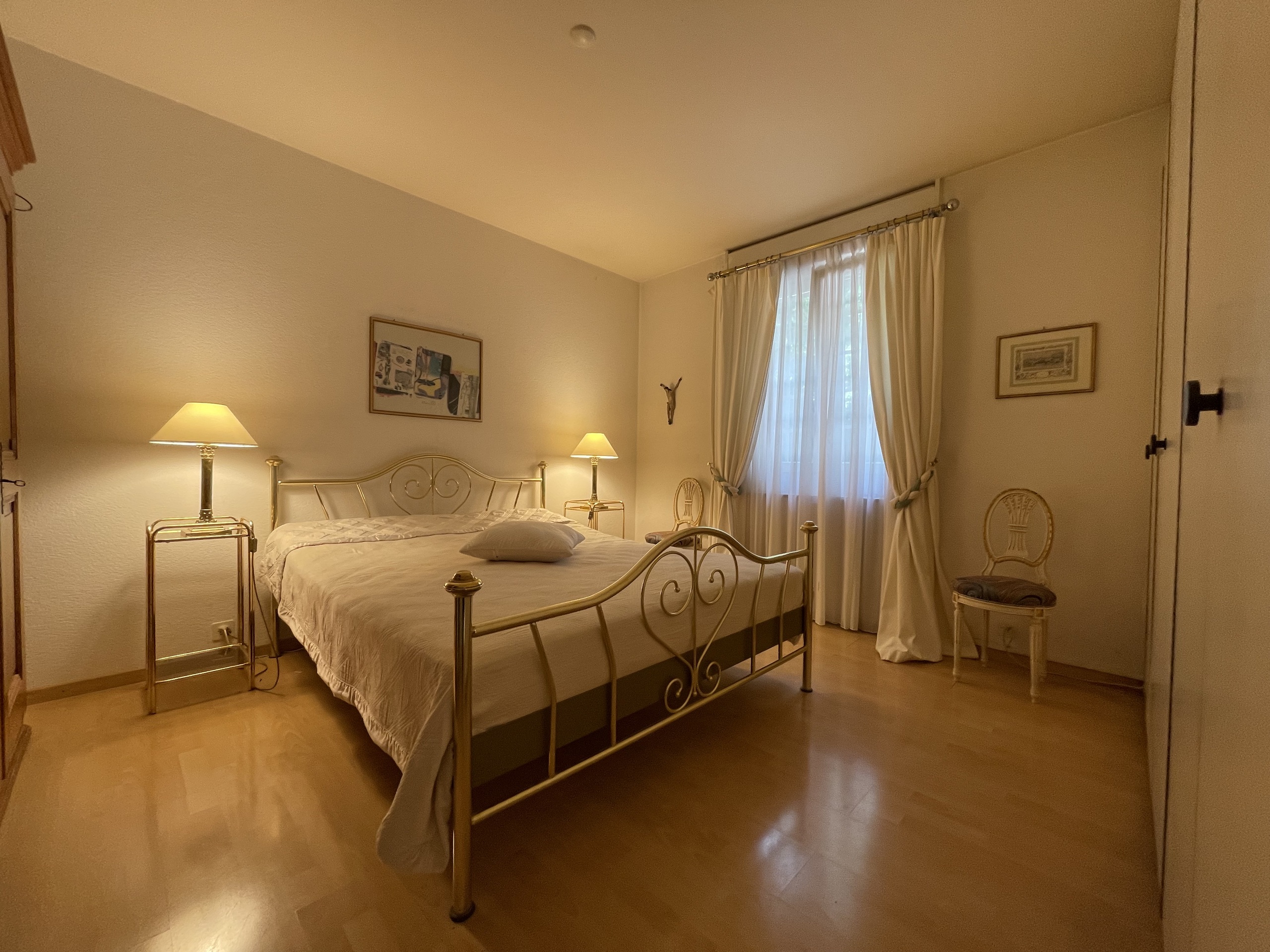 Schlafzimmer mit Metallbett und warmem Licht