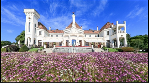 Luxuriöses Herrenhaus mit symmetrischer Fassade und Blumenbeet