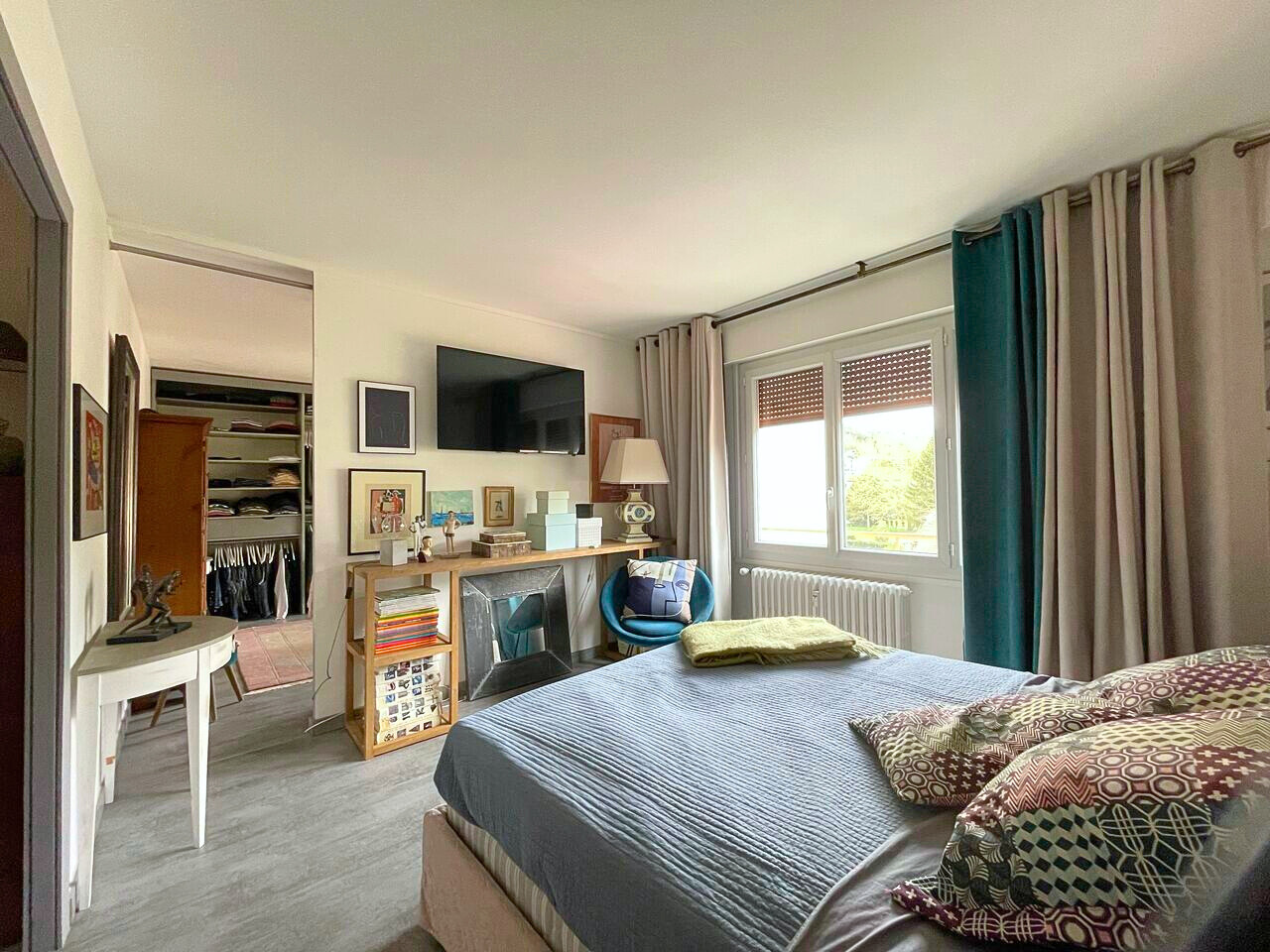 Helles Schlafzimmer mit Schreibtisch- und Kleiderschrankbereich