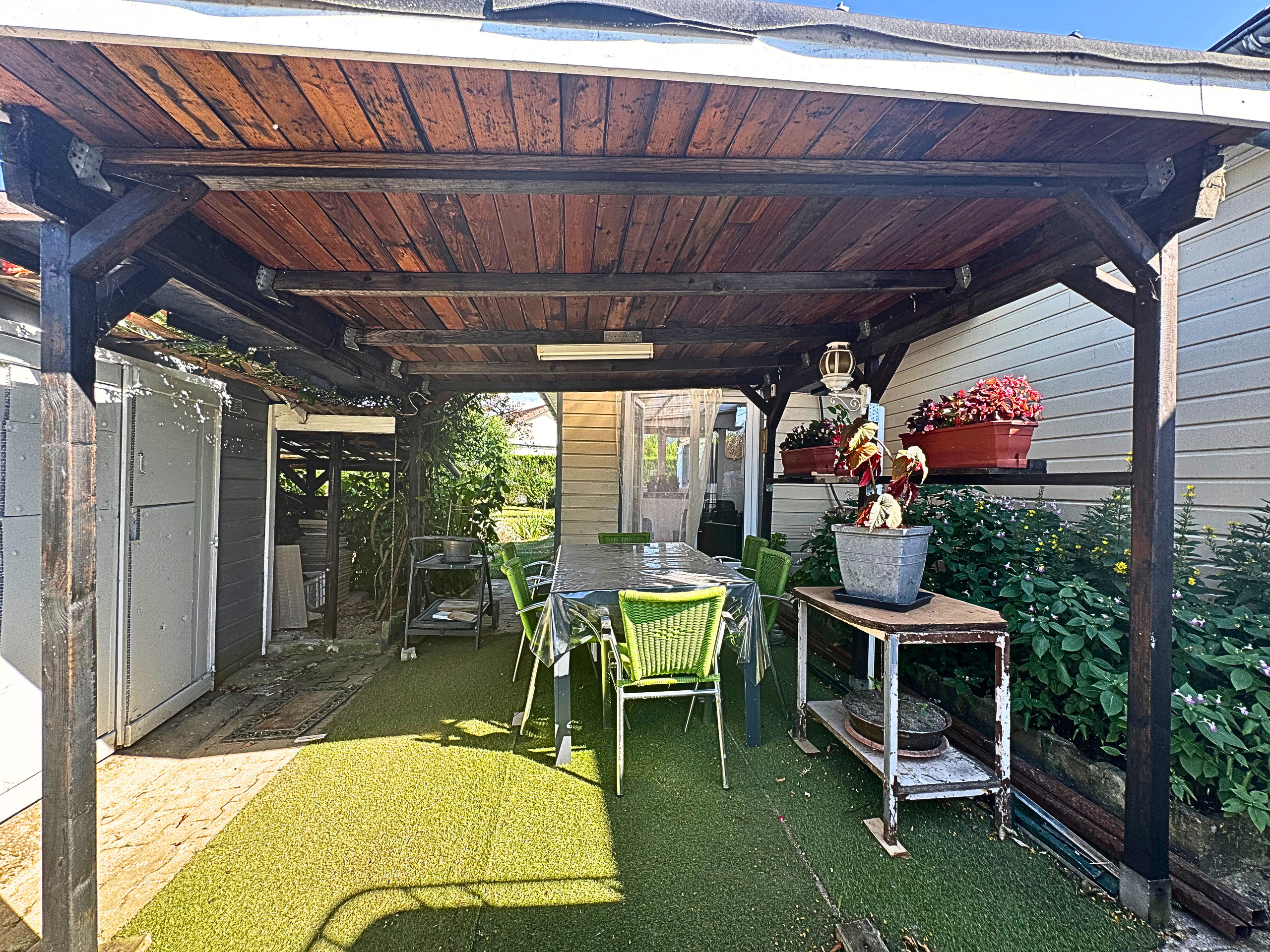 Überdachte Terrasse mit Sitzecke und Pflanzen
