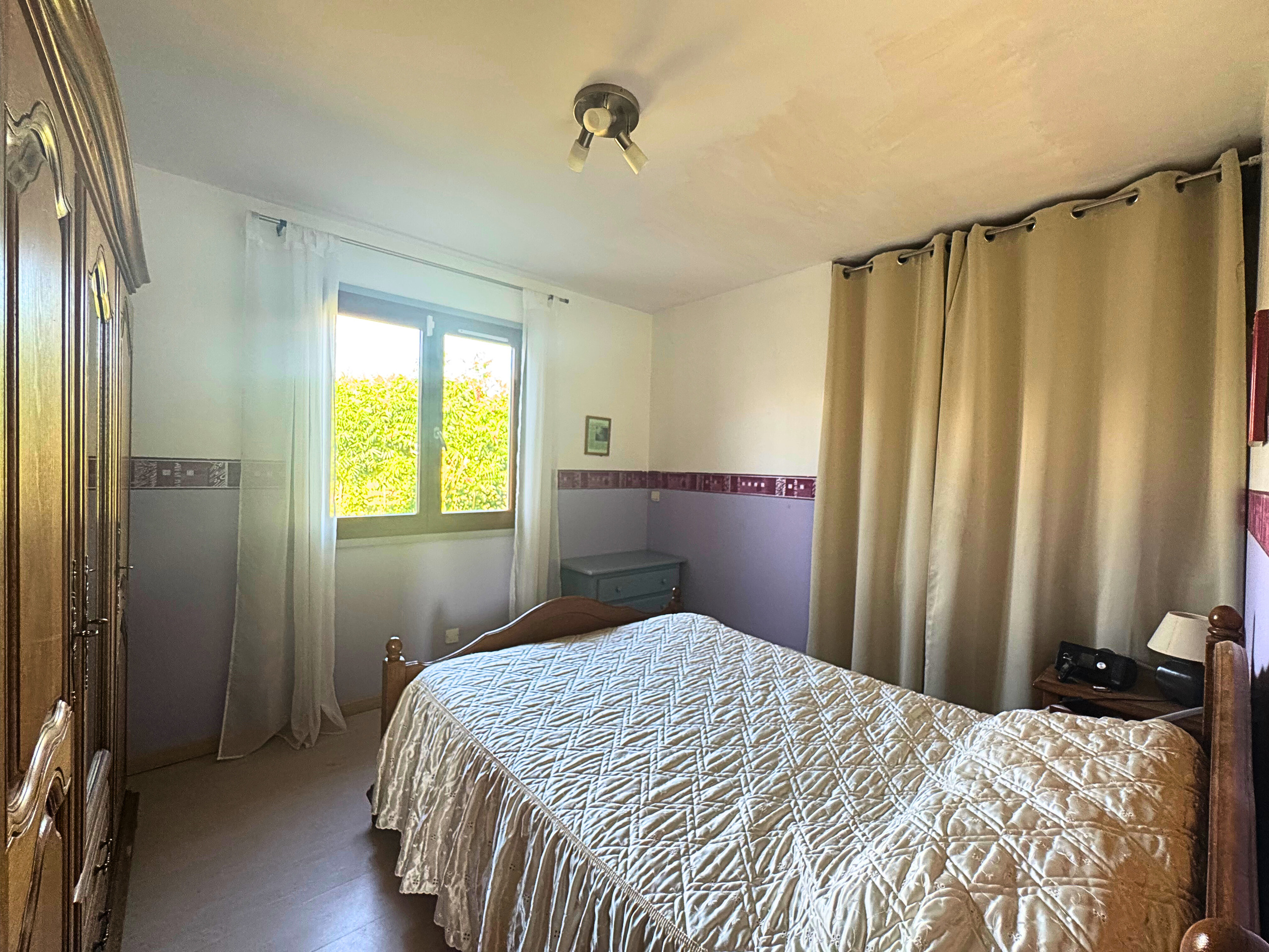 Gemütliches Schlafzimmer mit Doppelbett und Fensterblick
