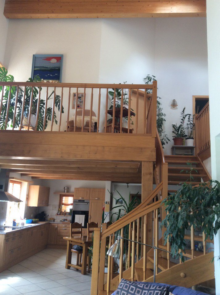 Offener Wohnbereich mit Holztreppe und Galerie