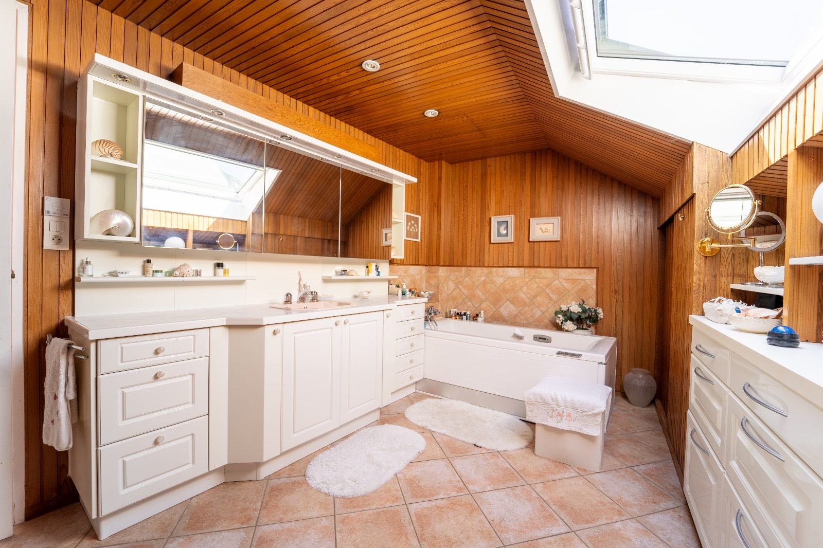Helles Badezimmer mit Holzvertäfelung und Dachfenster