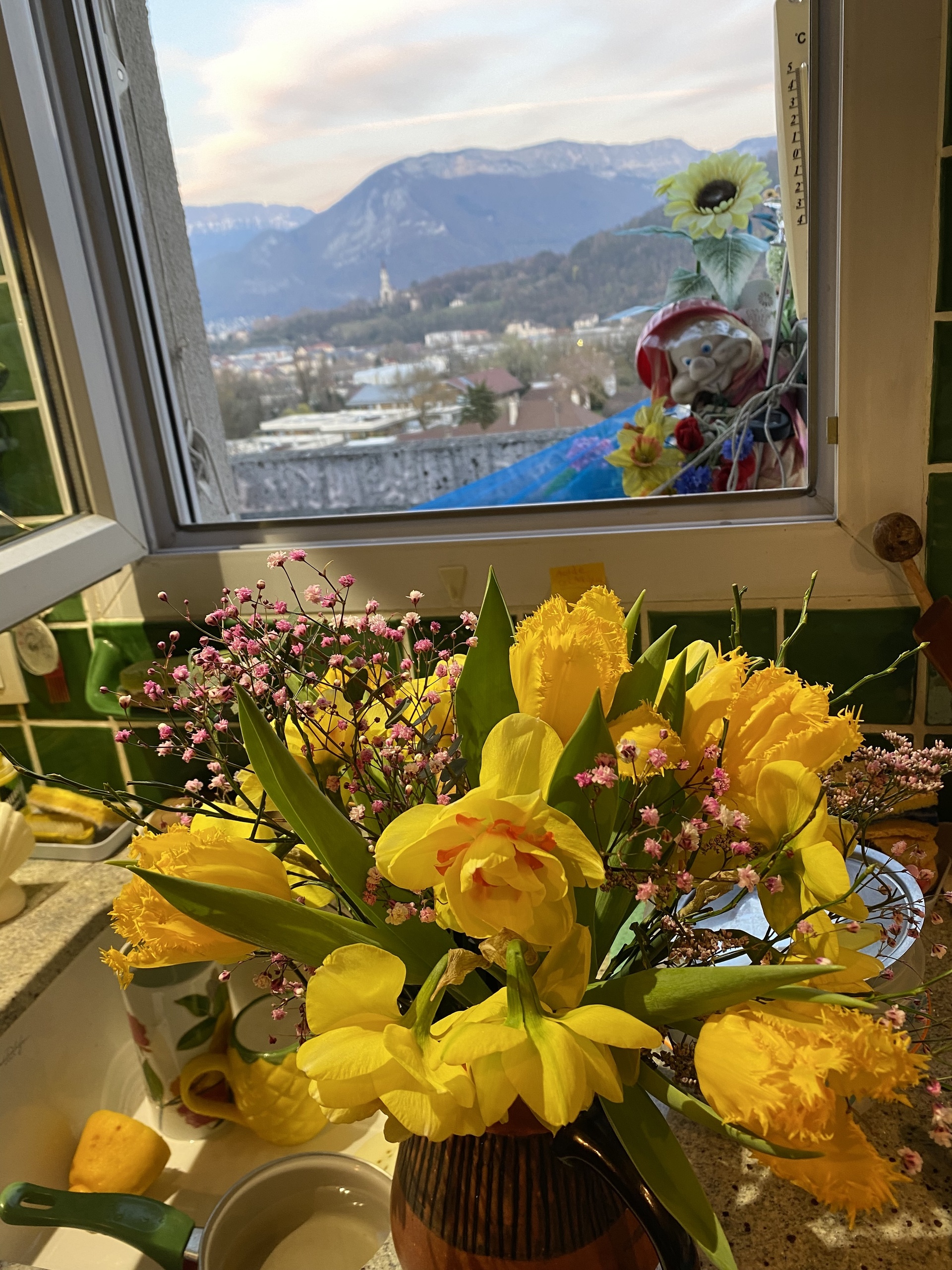 Küchenfenster mit Bergblick und Blumenarrangement