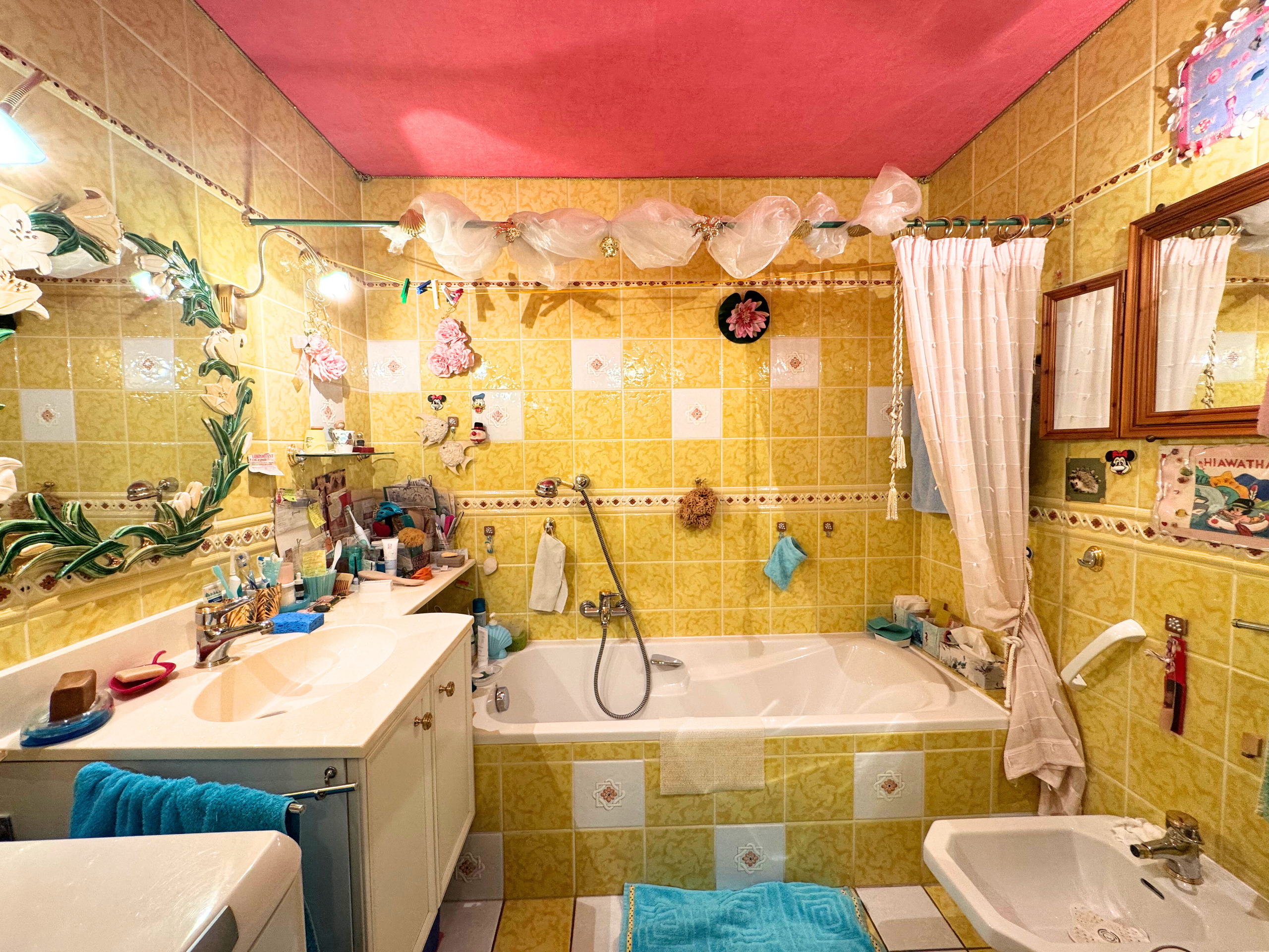 Bunt gefliestes Badezimmer mit Badewanne und Doppelwaschplatz