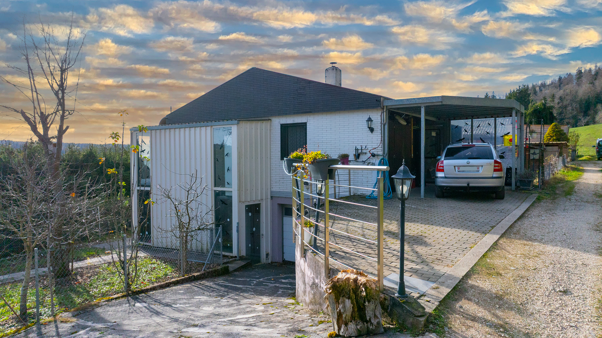 Haus mit Carport und Gartenhang