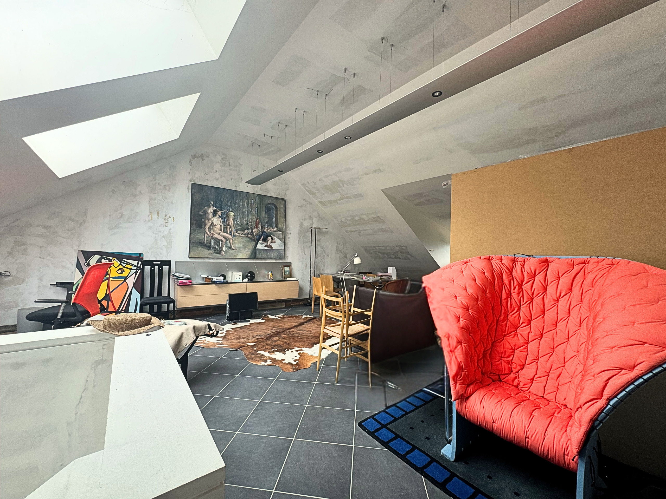 Dachgeschossraum mit schräger Decke und moderner Möblierung