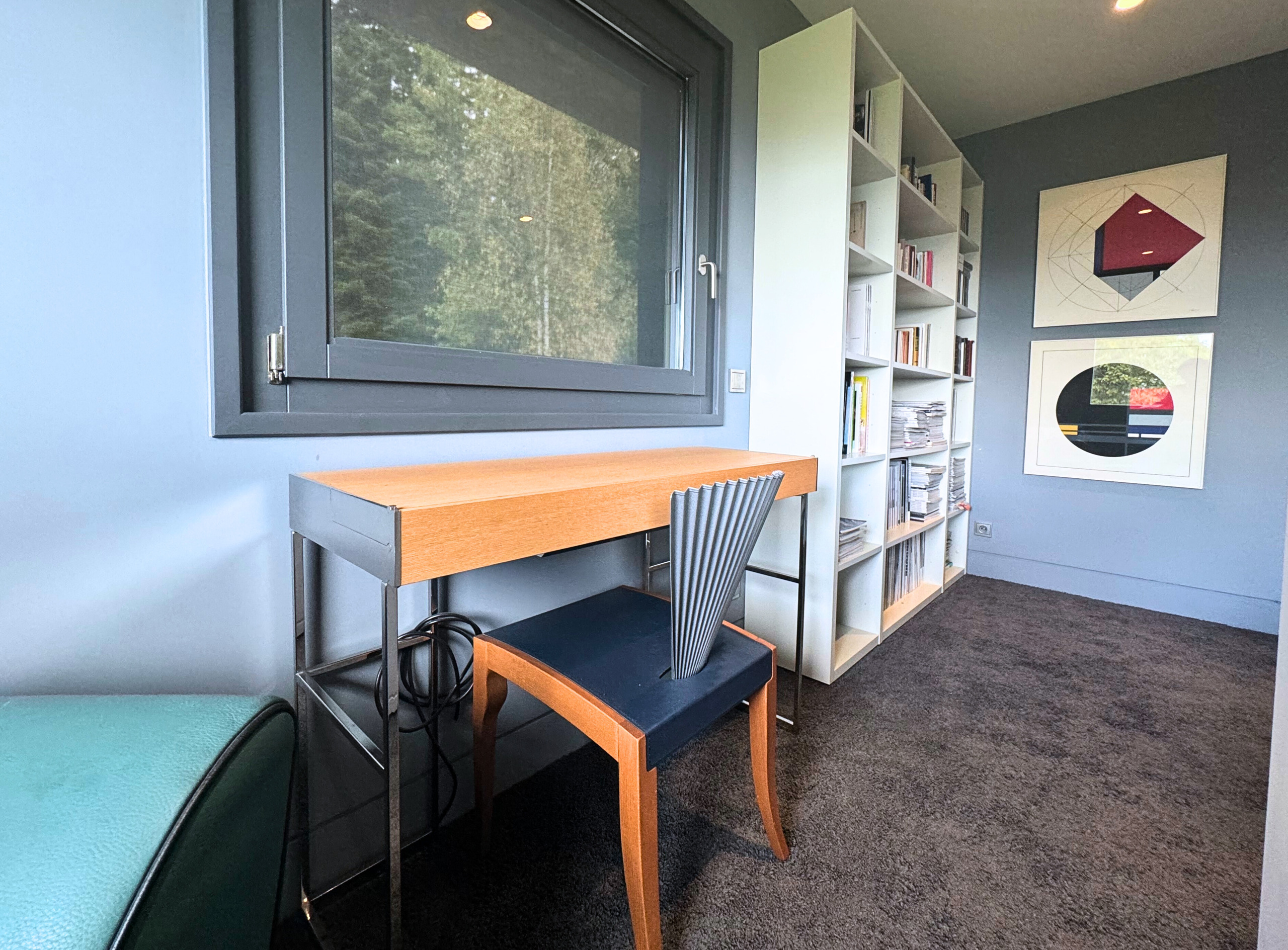 Modernes Arbeitszimmer mit Fenster und Bücherregal