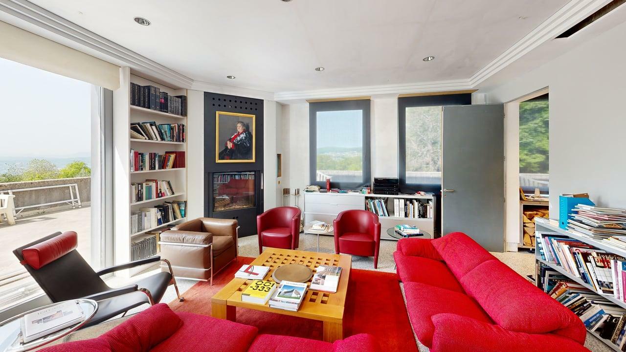 Hell eingerichtetes Wohnzimmer mit Kamin und Ausblick