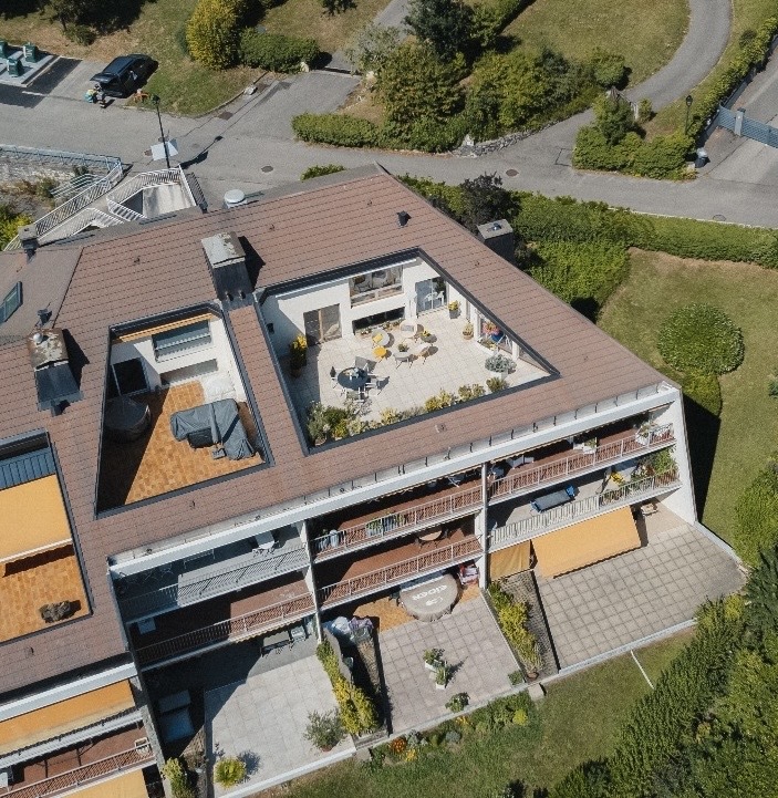 Luftaufnahme eines Mehrfamilienhauses mit Dachterrassen